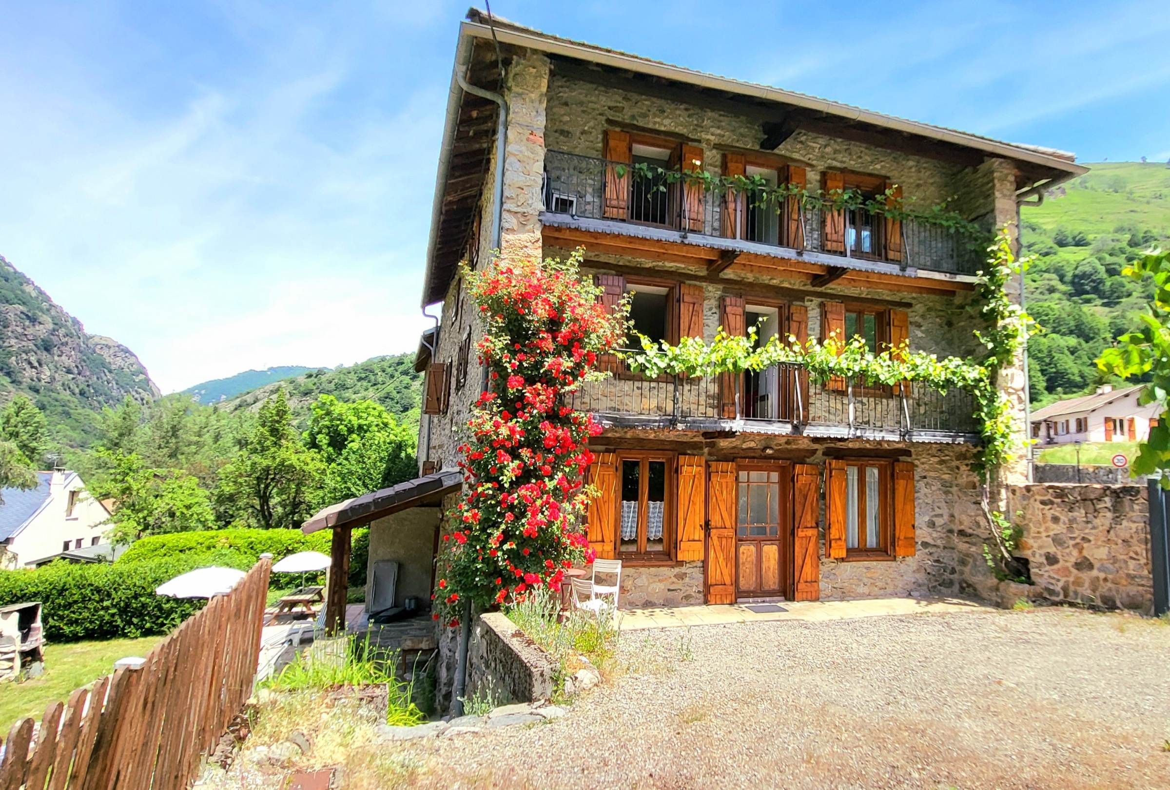 Façade fleurie et balcons de la maison en pierre
